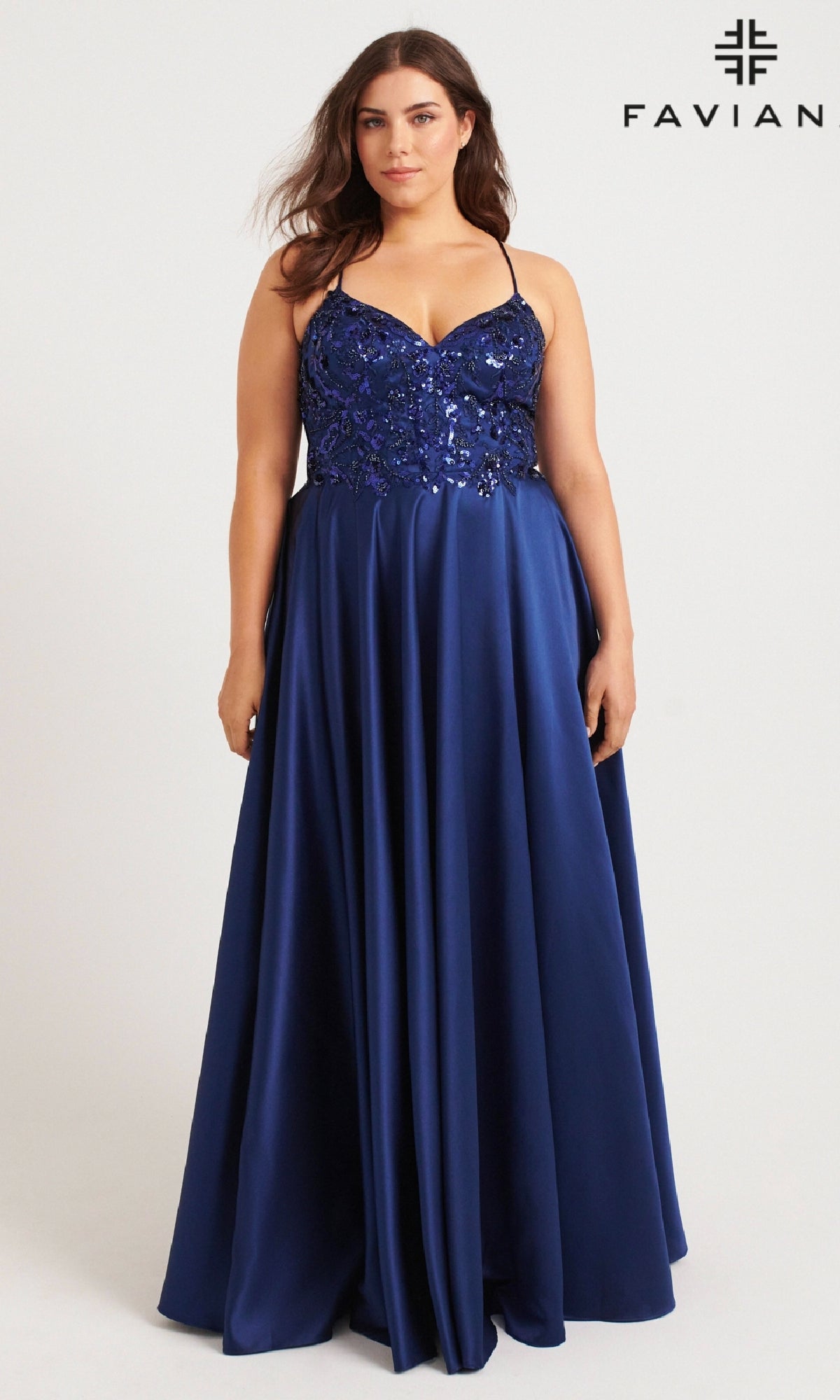 A woman models the Faviana 9578 long plus-size prom dress, featuring a sleeveless royal blue sequin embroidered bodice and satin skirt, against a plain background with the FAVIAN logo visible in the corner.